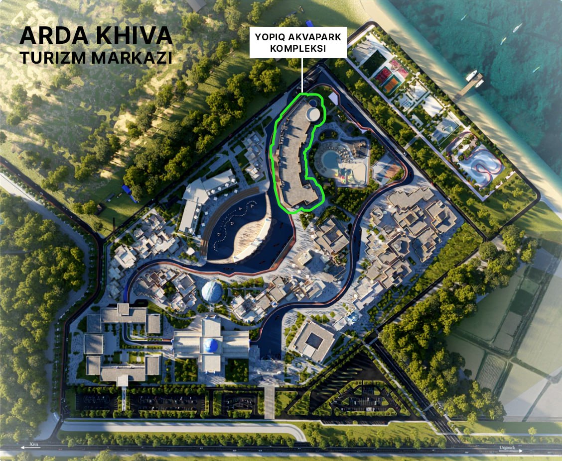 An aerial view shows Yopiq Akvapark Kompleksi in Turizm Markazi, surrounded by green spaces, roads, and water bodies.